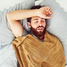 Young man snoring in bed.