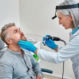 ENT specialist about to perform a nasal endoscopy on a patient