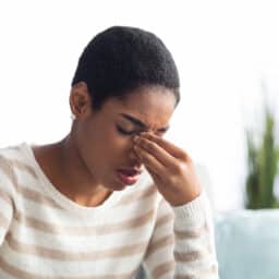Woman holding her nasal bridge