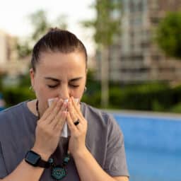 Woman blows nose in city park