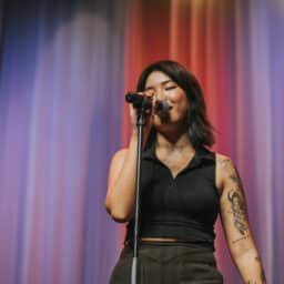 Woman singing on a colorful stage