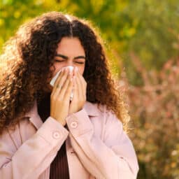 Woman with allergies sneezes