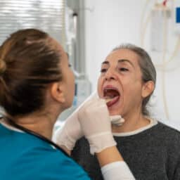 ENT examining a senior woman's throat