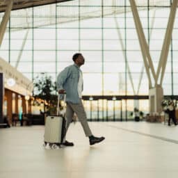Man Walking with Suitcase in Modern Airport Terminal