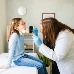 Young girl getting a throat exam at the ENT.