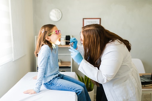 Young girl getting a throat exam at the ENT.