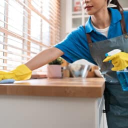 Woman cleaning her home and wiping with microfiber cloth in kitchen room