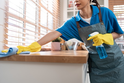 Woman cleaning her home and wiping with microfiber cloth in kitchen room