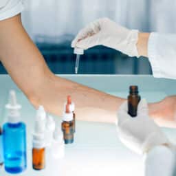 Doctor administering an allergy skin test on a patient's arm.