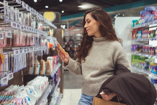 Young woman browsing health and beauty products such as cosmetics inside a drugstore.