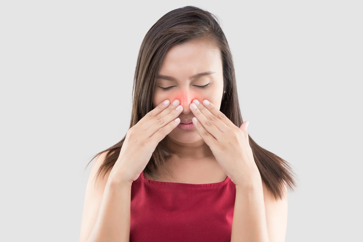 Woman touching her red sinuses.