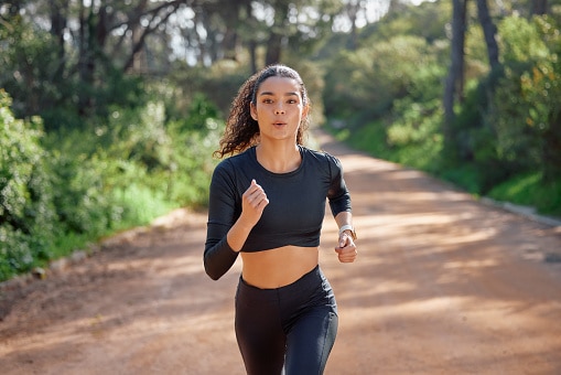 Fitness, running and woman in nature for exercise.